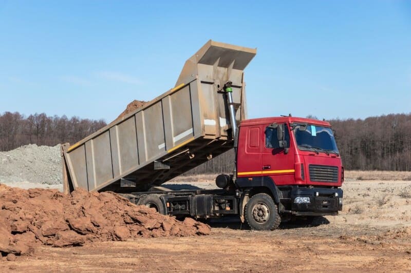 Caminhão basculante realiza a descarga de material.