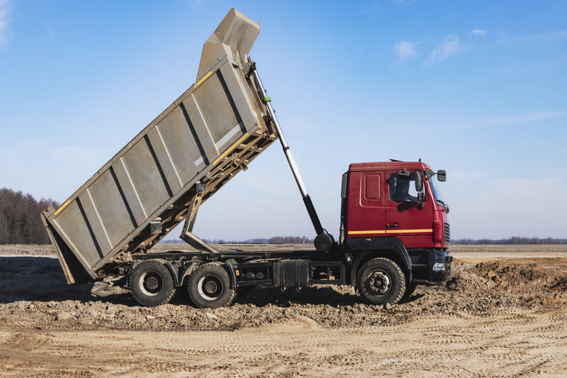 Operação de um caminhão basculante descarregando materiais pesados.